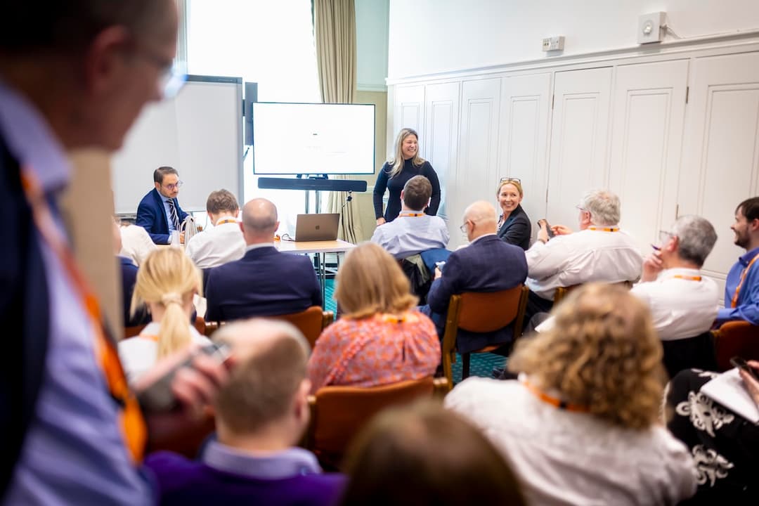 An image of a woman speaking to a room full of people